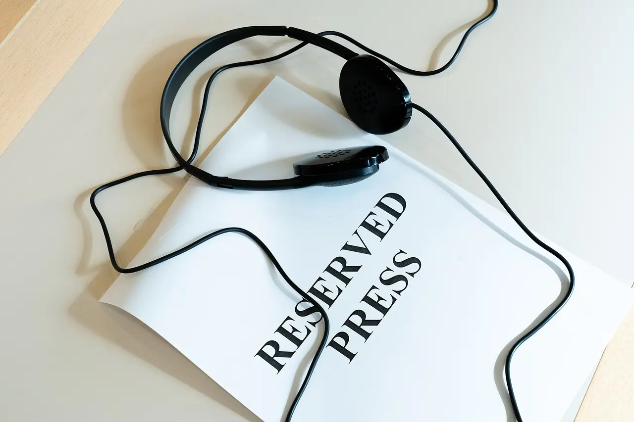 A pair of interpretation headphones lying on a reserved seat sign.